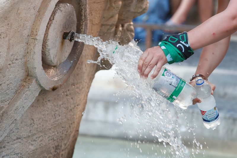 &copy; Reuters. Alcuni turisti riempiono le loro bottiglie d'acqua alla fontana della Barcaccia in Piazza di Spagna, a Roma, 1 agosto 2018. REUTERS/Alessandro Bianchi
