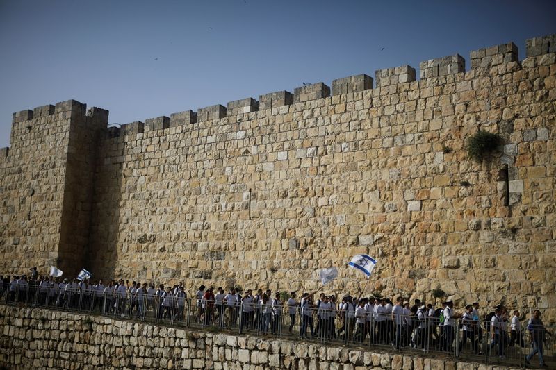 &copy; Reuters. FOTO DO ARQUIVO: Jovens agitam bandeiras israelenses durante desfile que marca Dia de Jerusalém enquanto marcham ao redor dos muros que cercam a Cidade Velha de Jerusalém
10/05/2021 REUTERS/Nir Elias