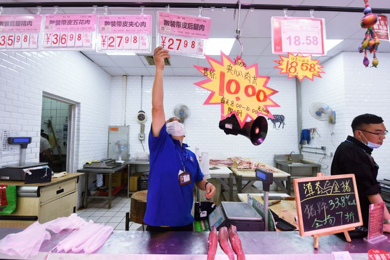 &copy; Reuters. Membros trabalhadores colocando placas de preços em mercado de carne de porco em Hangzhou, na China.
12/05/2020
China Daily via REUTERS