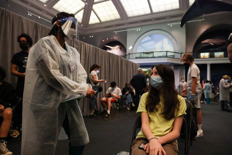&copy; Reuters. FILE PHOTO: Jane Hassebroek speaks with a healthcare professional after receiving the COVID-19 vaccine at the American Museum of Natural History in Manhattan, New York City, New York, U.S., May 14, 2021. REUTERS/Caitlin Ochs