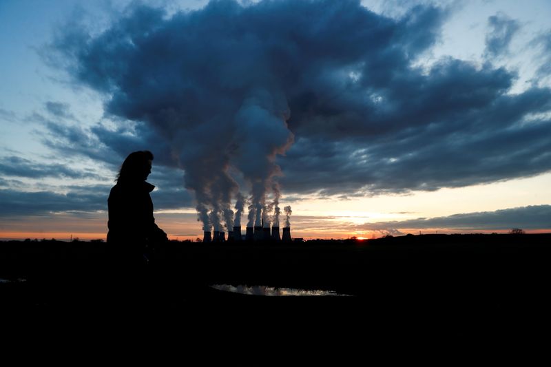 &copy; Reuters. FILE PHOTO: A woman walks a dog past Drax power station during the sunset in Drax, North Yorkshire, Britain, November 27, 2020. REUTERS/Lee Smith/File Photo