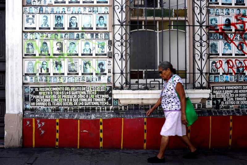 &copy; Reuters. FILE PHOTO: A woman walks in front of a wall with images of people disappeared during the Guatemala civil war ahead of Sunday's presidential election in Guatemala City, Guatemala June 12, 2019.  REUTERS/Saul Martinez/File Photo