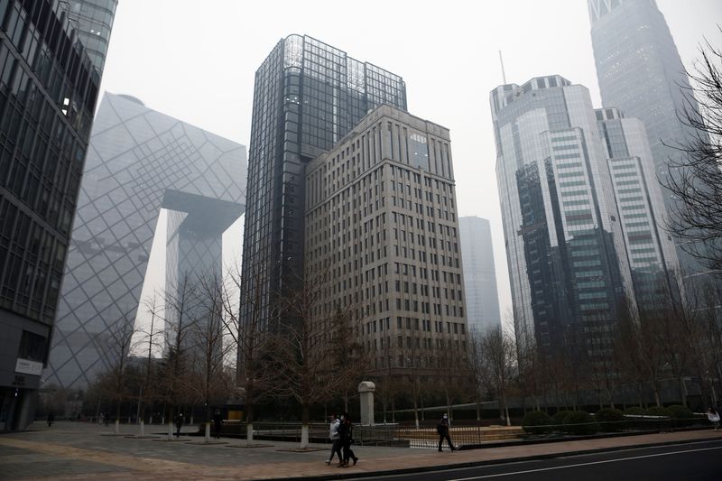 &copy; Reuters. FILE PHOTO: People walk at the Beijing's central business district (CBD), on the day of the opening session of the National People's Congress (NPC) in Beijing, China March 5, 2021. REUTERS/Tingshu Wang