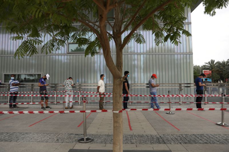 &copy; Reuters. أشخاص يضعون كمامات للوجه يصطفون لإجراء فحوصات للكشف عن الإصابة بفيروس كورونا في أبوظبي بصورة من أرشيف رويترز.