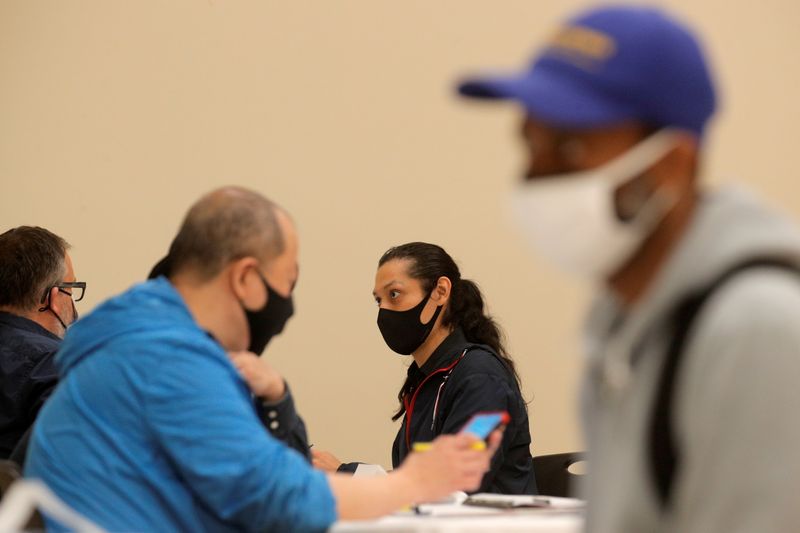 © Reuters. FILE PHOTO: Applicants talk with recruiters during a restaurant job career fair organized by the industry group High Road Restaurants in New York City, U.S., May 13, 2021.  REUTERS/Brendan McDermid