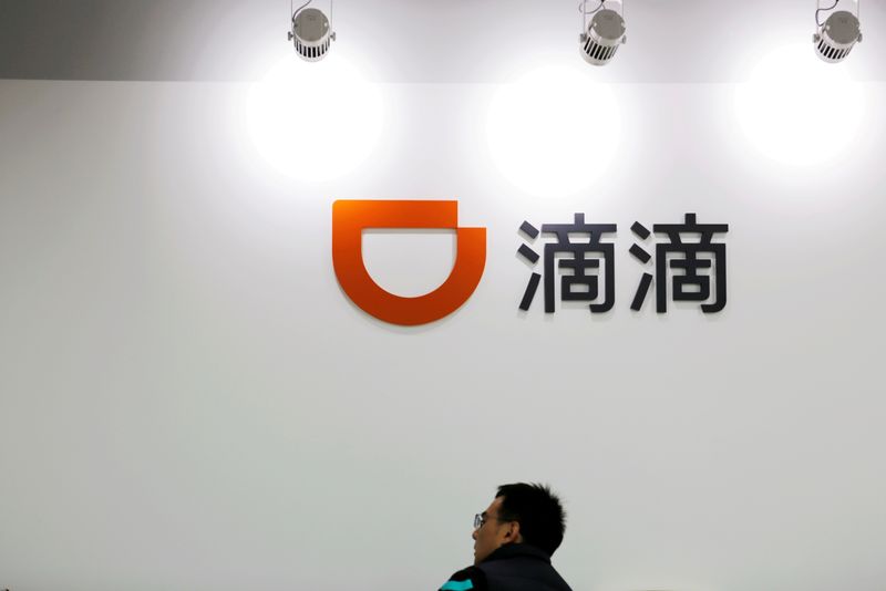 &copy; Reuters. FILE PHOTO: A man is seen under a Didi logo at the headquarters of Didi Chuxing in Beijing, China November 20, 2020. REUTERS/Florence Lo