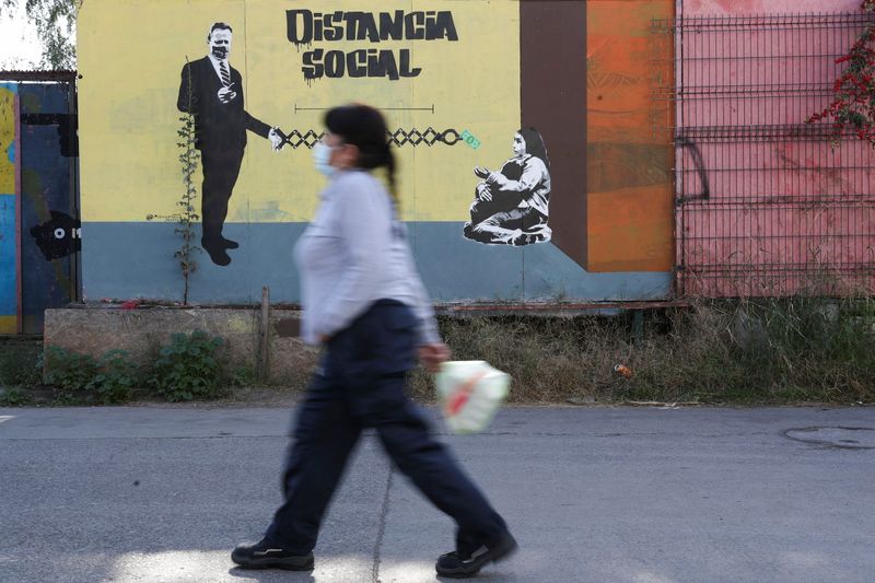 &copy; Reuters. FILE PHOTO: A woman walks past a graffiti reading 'Social distance' during the outbreak of the coronavirus disease (COVID-19) in Santiago, Chile June 7, 2021. REUTERS/Ivan Alvarado