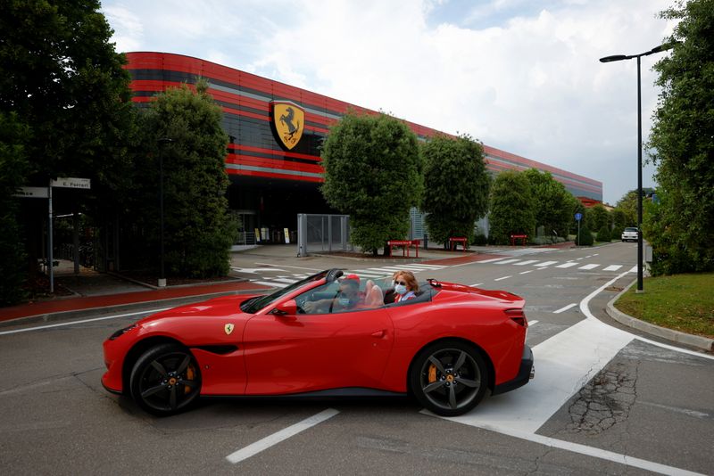 &copy; Reuters. A man drives a Ferrari past the company's headquarters in Maranello, Italy, June 8, 2021. Picture taken June 8, 2021. REUTERS/Guglielmo Mangiapane