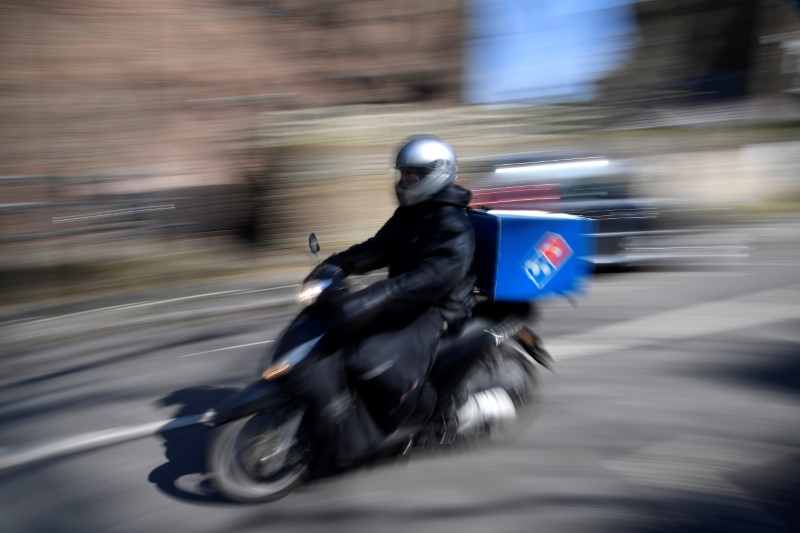 &copy; Reuters. A Domino's pizza delivery person drives a scooter in a residential street, as the spread of the coronavirus disease (COVID-19) continues, in west London, Britain, March 24, 2020. REUTERS/Toby Melville