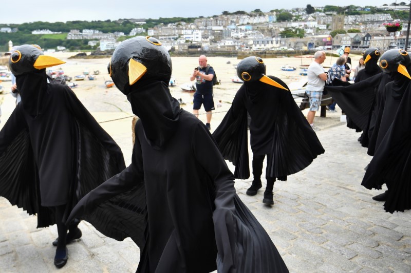 &copy; Reuters. Climate change activists dressed up as black birds protest in St. Ives, on the sidelines of G7 summit in Cornwall, Britain, June 11, 2021. REUTERS/Dylan Martinez