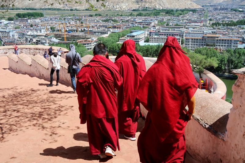 &copy; Reuters. Tibetan Buddhist monks walk on the grounds of the Potala Palace overlooking the city of Lhasa, during a government-organised media tour to Tibet Autonomous Region, China June 1, 2021. REUTERS/Martin Pollard