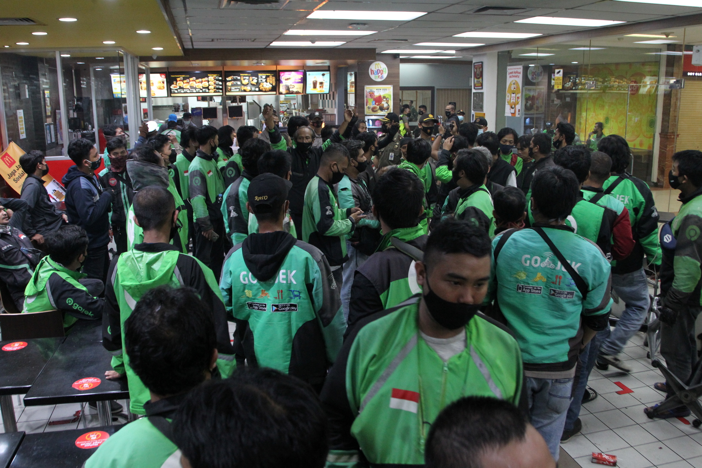&copy; Reuters. Food delivery drivers crowd in a McDonald's restaurant and wait for BTS meal orders in Bogor, Indonesia, June 9, 2021 in this picture obtained from social media. SOFYAN SHAH RADAR BOGOR/via REUTERS
