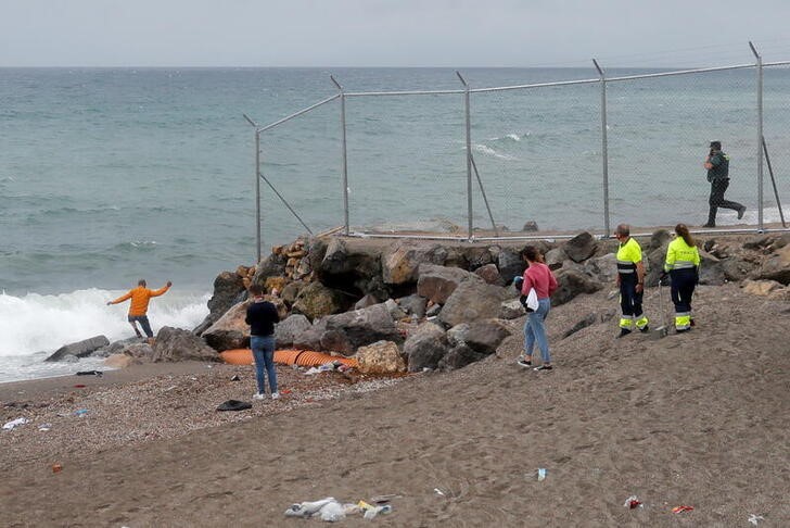 &copy; Reuters. Un hombre cerca de la valla de la frontera hispano-marroquí intenta entrar de nuevo en Marruecos, después de que miles de migrantes cruzaran a nado esta frontera durante los últimos días, en la playa de El Tarajal, Ceuta, España, el 20 de mayo,2021. 