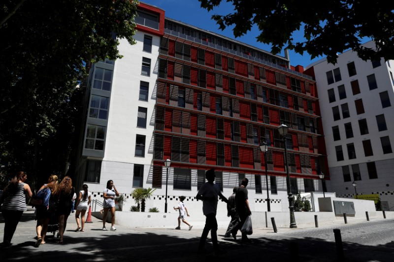 &copy; Reuters. FOTO DE ARCHIVO: Gente ante un complejo de apartamentos que anuncia "Propiedades y estacionamiento disponibles" en Madrid, 19 de junio de 2019. REUTERS/Susana Vera