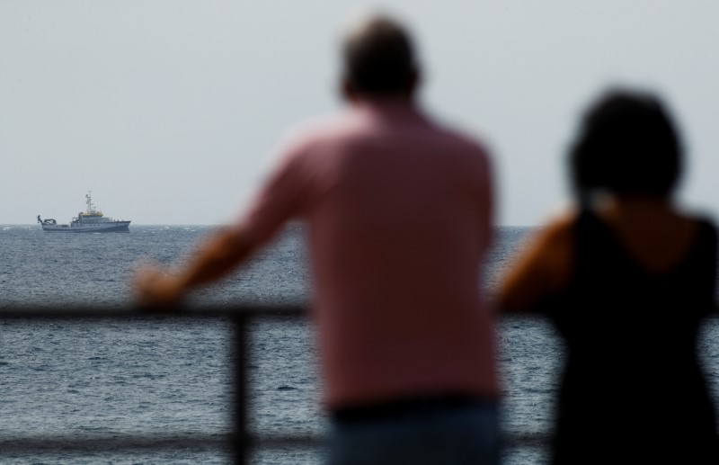 &copy; Reuters. Dos personas observan el mar mientras el buque Ángeles Alvariño lleva a cabo la búsqueda de dos niñas desaparecidas y su padre cerca de la costa de Tenerife, Islas Canarias, España, el 11 de junio de 2021. REUTERS//Borja Suárez