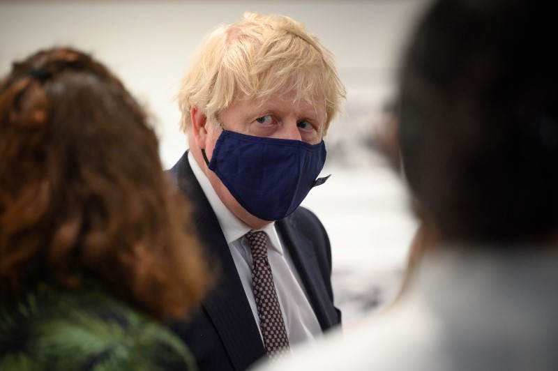 &copy; Reuters. FILE PHOTO: British Prime Minister Boris Johnson discusses the foreign aid cap with a member of an engagement group during a visit to Falmouth's Maritime Museum to meet volunteers and to thank them for hosting the media centre for the G7 Summit, in Falmou