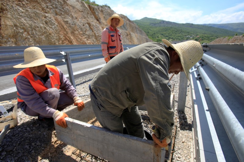 &copy; Reuters. FILE PHOTO: Workers fit a manhole on the Bar-Boljare section of a new highway in Montenegro financed with a large Chinese loan, May 27, 2021. REUTERS/Stevo Vasiljevic/File Photo