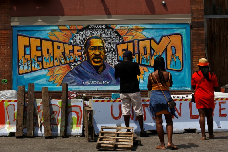 &copy; Reuters. أفراد من السود الأمريكيين يتفقدون جدارية في ساحة جورج فلويد في مينيابوليس بولاية مينيسوتا الأمريكية يوم 3 يونيو حزيران 2021. تصوير: نيكول نيري