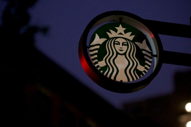 © Reuters. FILE PHOTO: Traffic lights illuminate a Starbucks sign before the 5am opening of a Center City Starbucks, where two black men were arrested, in Philadelphia, Pennsylvania U.S., May 29, 2018.  REUTERS/Mark Makela/File Photo
