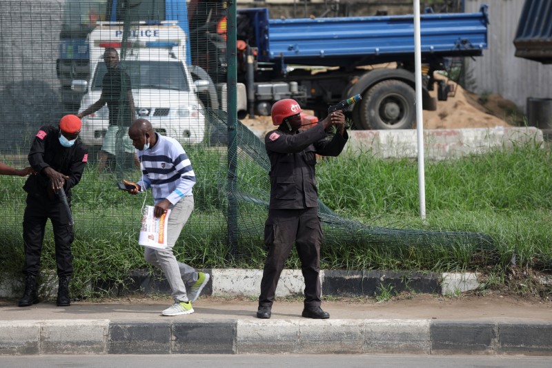 © Reuters. ضابط شرطة يستعد لاطلاق غاز مسيل للدموع لتفريق المتظاهرين في لاجوس بنيجيريا يوم السبت. تصوير:رويترز.