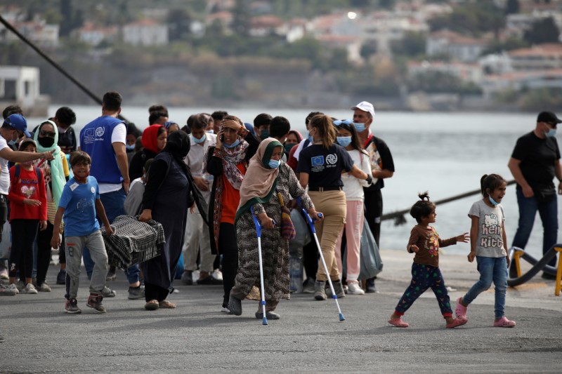 &copy; Reuters. FILE PHOTO: Refugees and migrants from the destroyed Moria camp wait to board a ferry that will transfer them to the mainland, at the port of Mytilene on the island of Lesbos, Greece, September 28, 2020. REUTERS/Elias Marcou/File Photo