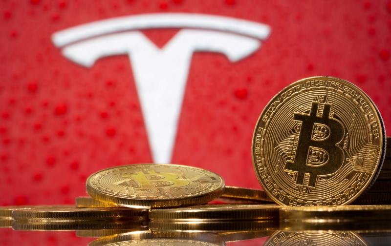 &copy; Reuters. FILE PHOTO: Representations of virtual currency bitcoin are seen in front of Tesla logo in this illustration taken, February 9, 2021. REUTERS/Dado Ruvic/File Photo