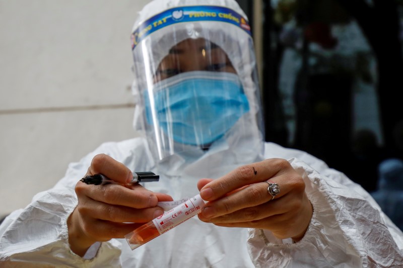 &copy; Reuters. FOTO DE ARCHIVO: Un trabajador sanitario analiza una muestra de COVID-19 en Hanói, Vietnam, el 29 de enero de 2021. REUTERS/Kham