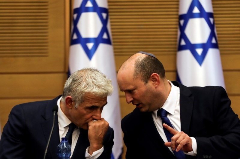 &copy; Reuters. بينيت (إلى اليمين) وبجواره يائير لابيد في الكنيست الإسرائيلي في القدس يوم الاحد. تصوير: رونن زفولن - رويترز.

