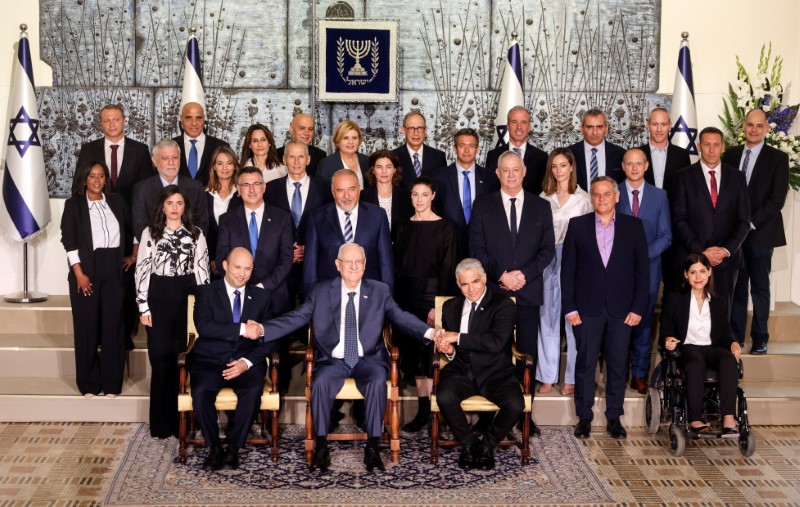 © Reuters. Israel's President Reuven Rivlin sits next to Prime Minister Naftali Bennett as they pose for a group photo together with ministers of the new Israeli government, in Jerusalem June 14, 2021. REUTERS/Ronen Zvulun