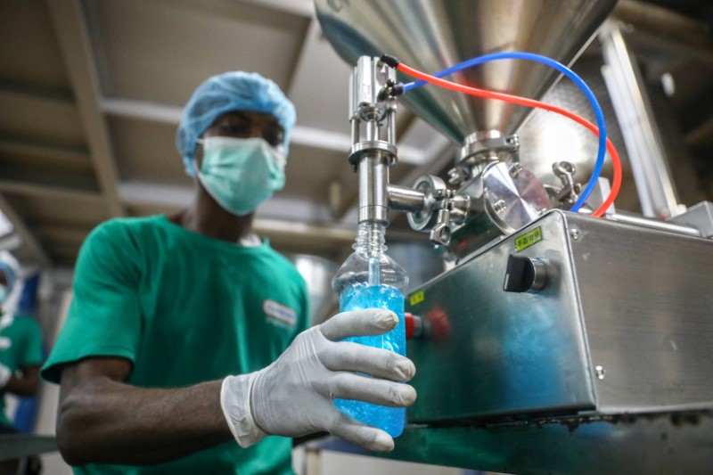 &copy; Reuters. FILE PHOTO: An employee fills a bottle with hand sanitizer in Cormart factory as the company steps up production of hand sanitizers to prevent the spread of coronavirus disease (COVID-19), on the outskirts of Lagos, Nigeria March 19, 2020. Picture taken M