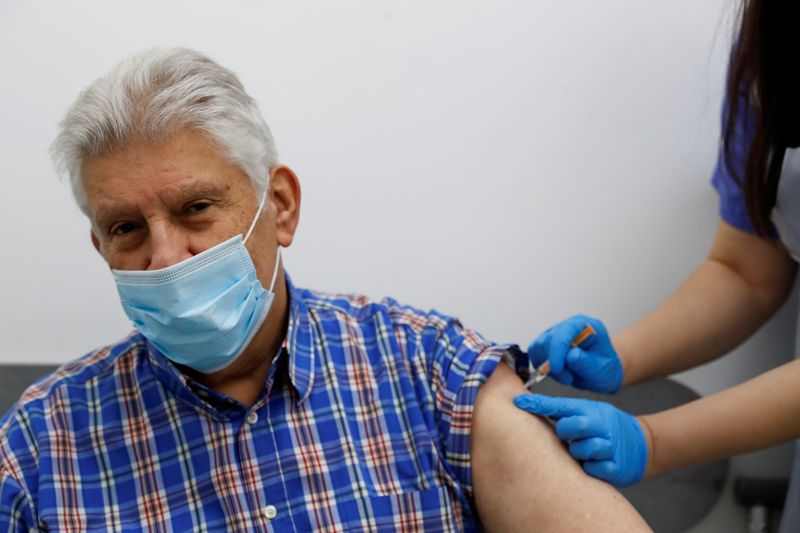 &copy; Reuters. FILE PHOTO: An elderly person receives a dose of the Oxford/AstraZeneca COVID-19 vaccine at Cullimore Chemist, in Edgware, London, Britain January 14, 2021. REUTERS/Paul Childs/File Photo