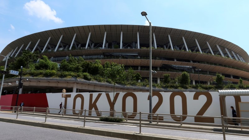 &copy; Reuters. FILE PHOTO: People walk outside the security fence of Olympic Stadium (National Stadium) built for Tokyo Olympic Games, that have been postponed to 2021 due to the coronavirus disease (COVID-19) outbreak, in Tokyo, Japan June 11, 2021. REUTERS/Pawel Kopcz