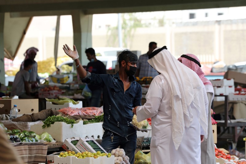 &copy; Reuters. FILE PHOTO: A Saudi man wearing a protective face mask sells fruit at a market, after Saudi Arabia imposed a temporary lockdown on the province of Qatif following the spread of coronavirus, in Qatif, Saudi Arabia March 9, 2020. REUTERS/Stringer