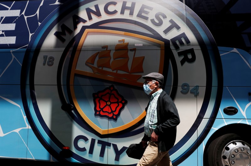&copy; Reuters. FILE PHOTO: Soccer Football - Champions League - Manchester City arrive in Porto ahead of the Champions League Final Manchester City v Chelsea - Porto, Portugal - May 27, 2021 A man walks past a Manchester City team bus in Porto ahead of the Champions Lea