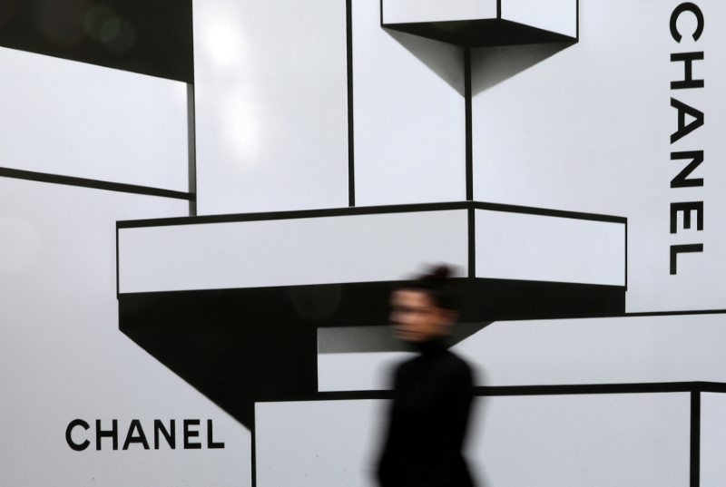 &copy; Reuters. FILE PHOTO: A woman walks past a wall with logos of French luxury goods maker Chanel in Nice, France, February 22, 2017.    REUTERS/Eric Gaillard/File Photo