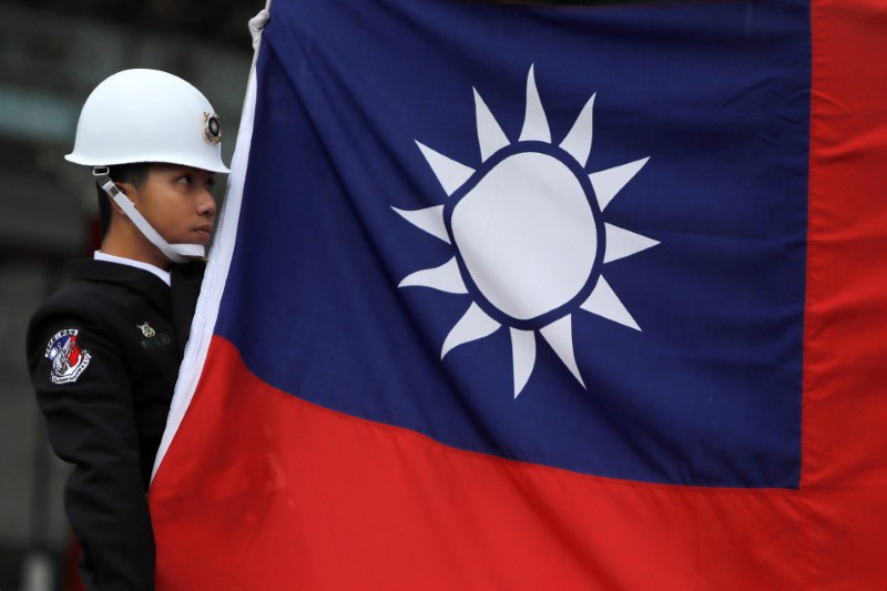 &copy; Reuters. FILE PHOTO: A military honour guard holds a Taiwanese national flag as he attending flag-raising ceremony at Chiang Kai-shek Memorial Hall, in Taipei, Taiwan March 16, 2018. REUTERS/Tyrone Siu/File Photo