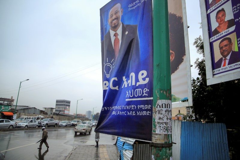 &copy; Reuters. FILE PHOTO: A man walks past an election campaign billboard depicting Ethiopian Prime Minister Abiy Ahmed, in Addis Ababa, Ethiopia, June 14, 2021. REUTERS/Tiksa Negeri/File Photo