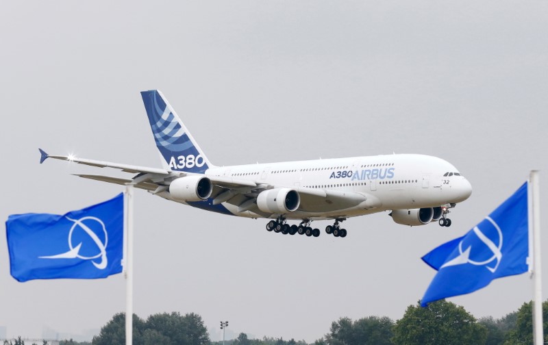 © Reuters. Aeronave da Airbus durante evento do setor em Paris, na França; em primeiro plano, bandeiras com o logo da norte-americana Boeing 
15/06/2015
REUTERS/Pascal Rossignol