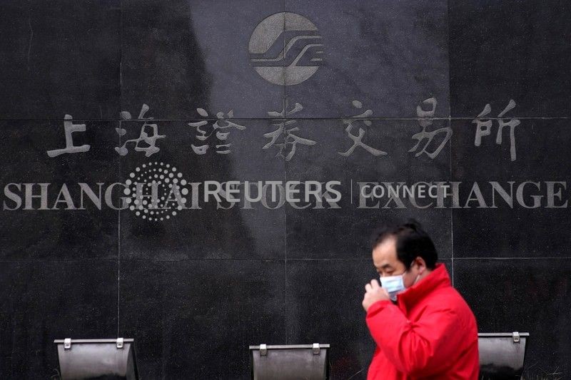 &copy; Reuters. Un uomo davanti all'insegna della Borsa di Shanghai . REUTERS/Aly Song
