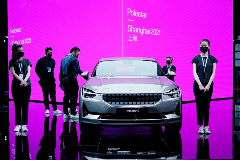 &copy; Reuters. FILE PHOTO: Staff members stand near a Polestar 2 electric vehicle (EV) displayed during a media day for the Auto Shanghai show in Shanghai, China April 20, 2021. REUTERS/Aly Song/File Photo