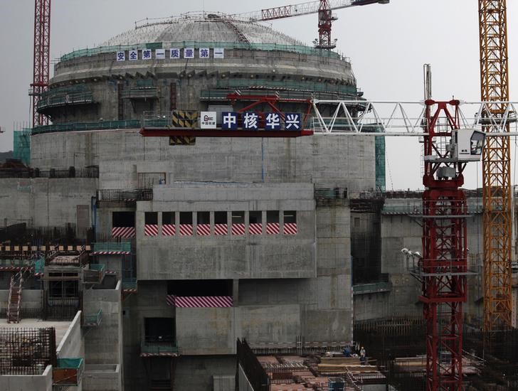 &copy; Reuters. Workers (bottom) stand in front of a nuclear reactor as part of the Taishan Nuclear Power Plant seen under construction in Taishan, Guangdong province, October 17, 2013. As China signs global deals to export its nuclear power technology, it faces a huge o