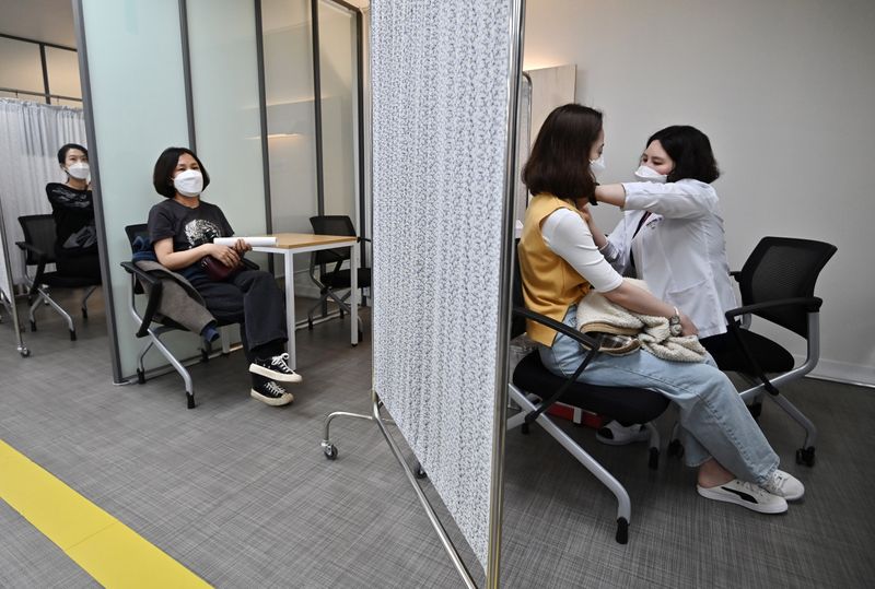 &copy; Reuters.     韓国当局は１６日、国民の２５％に新型コロナウイルスワクチンを少なくとも１回接種したとし、予定より２週間早く進展していることを明らかにした。写真はワクチン接種会場、ソウ