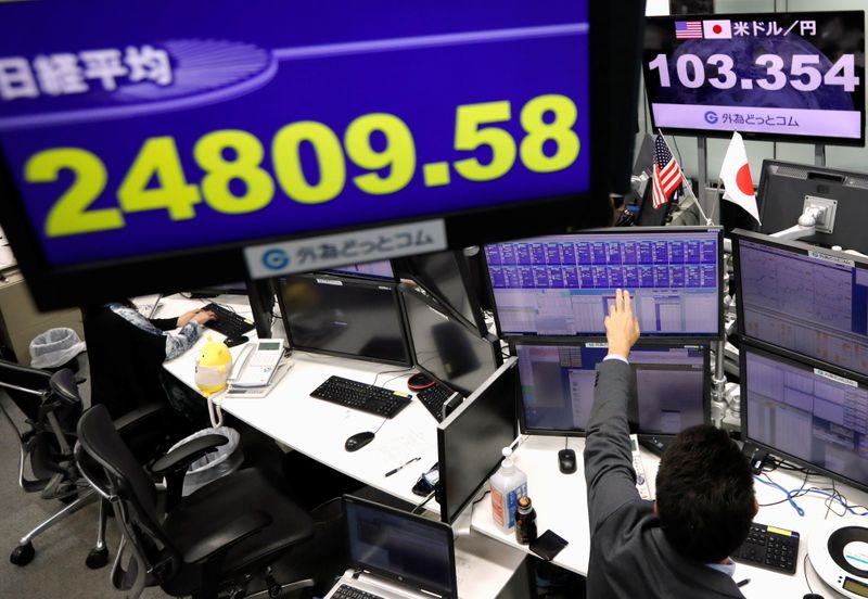 &copy; Reuters. An employee of the foreign exchange trading company works in front of monitors showing Japan's Nikkei share average and the Japanese yen exchange rate against the U.S. dollar at a dealing room in Tokyo, Japan November 9, 2020.  REUTERS/Issei Kato