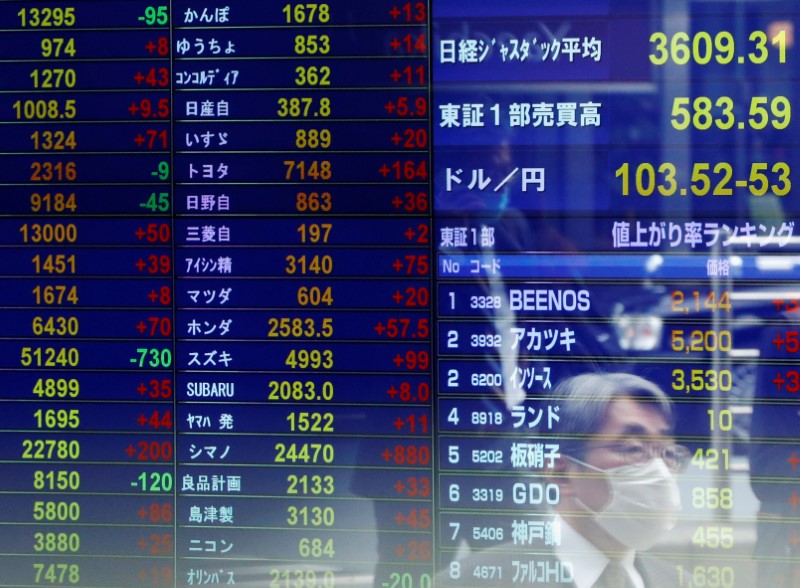 &copy; Reuters. Un uomo riflesso su uno schermo presso il distretto finanziario di Tokyo. REUTERS/Issei Kato