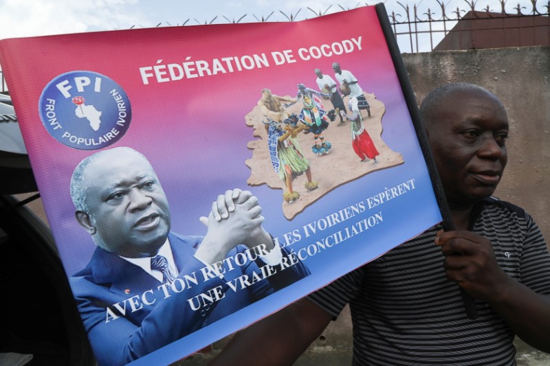 &copy; Reuters. A supporter holds a poster of former Ivorian president Laurent Gbagbo during the preparation of his return after being acquitted by the International Criminal Court on charges of war crimes, at his party's headquarters in Abidjan, Ivory Coast June 16, 202