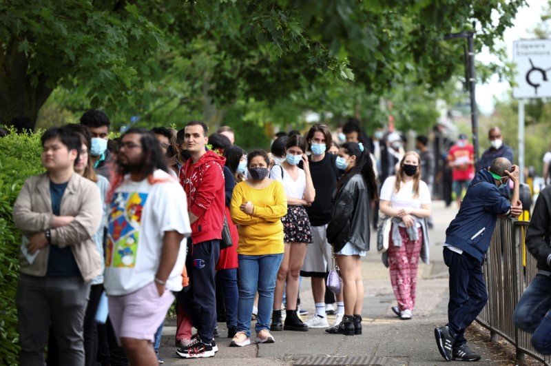&copy; Reuters. FILE PHOTO: People queue outside a vaccination centre for those aged over 18 years old at the Belmont Health Centre in Harrow,  in London, Britain, June 6, 2021. REUTERS/Henry Nicholls
