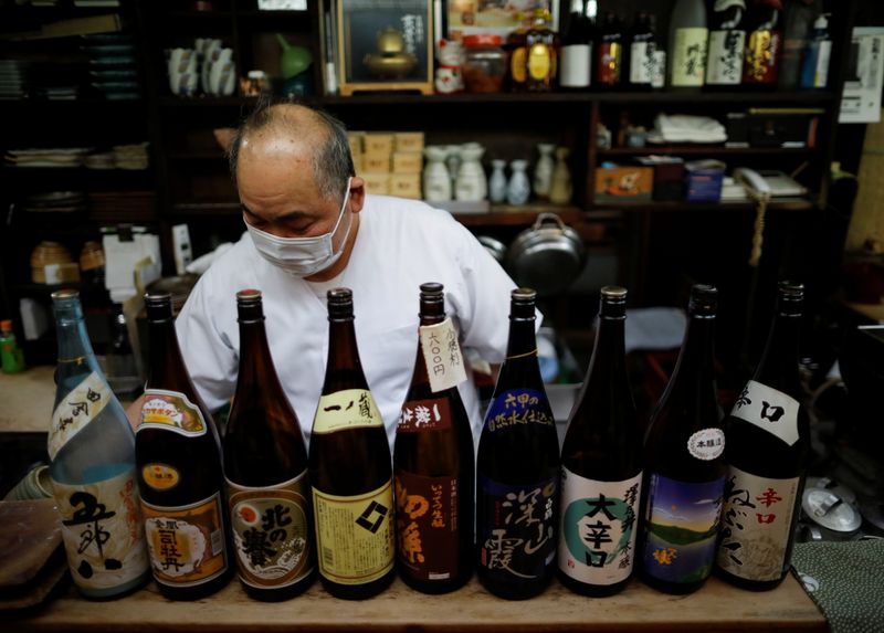 &copy; Reuters. The chef of an izakaya, a Japanese-style dining bar, prepares to close around 20:00 local time next to sake bottles, amid the coronavirus disease (COVID-19) outbreak, in Tokyo, Japan February 2, 2021. REUTERS/Issei Kato