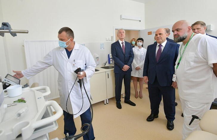 &copy; Reuters. Russia's Prime Minister Mikhail Mishustin and Moscow's Mayor Sergei Sobyanin stand next to Denis Protsenko, chief physician of City Clinical Hospital No. 40, during a visit to a medical centre for patients infected with the coronavirus disease (COVID-19) 