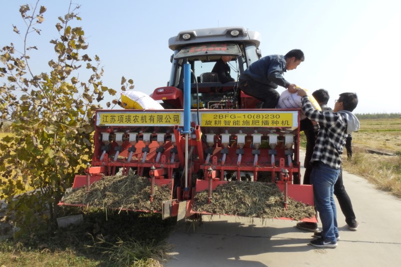 &copy; Reuters. Imagen de archivo de personas participando en un experimento con equipos agrícolas autónomos cargando fertilizante en un tractor autónomo cerca de un campo en Xinghua, provincia de Jiangsu, China. 30 de octubre, 2018. REUTERS/Hallie Gu/Archivo