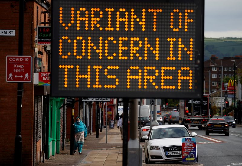 © Reuters. FILE PHOTO: A woman walks past an information sign amid the outbreak of the coronavirus disease (COVID-19) in Bolton, Britain, May 17, 2021. REUTERS/Phil Noble/File Photo